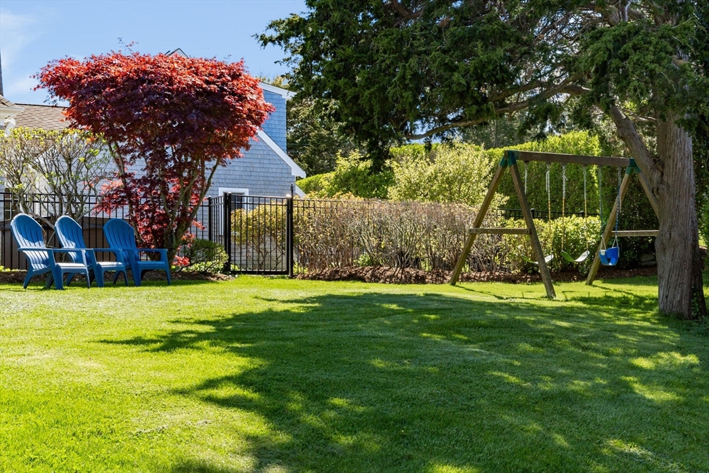 55 Cove Road Eastham, MA 02642 - Photo 10 of 42 a backyard of a house with plants and large tree