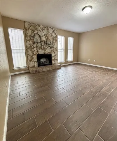 an empty room with windows and fireplace