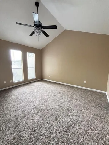 en empty room with windows and ceiling fan