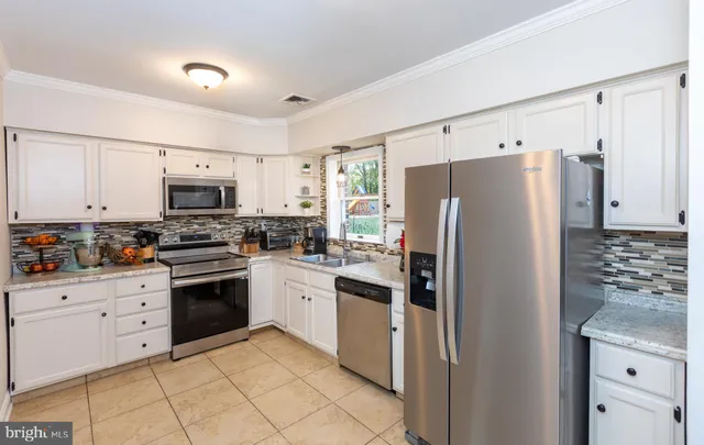 a kitchen with white cabinets and stainless steel appliances