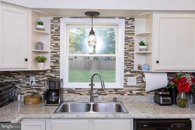a kitchen with a granite countertop sink and window