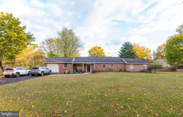 a view of a house with a big yard and large trees