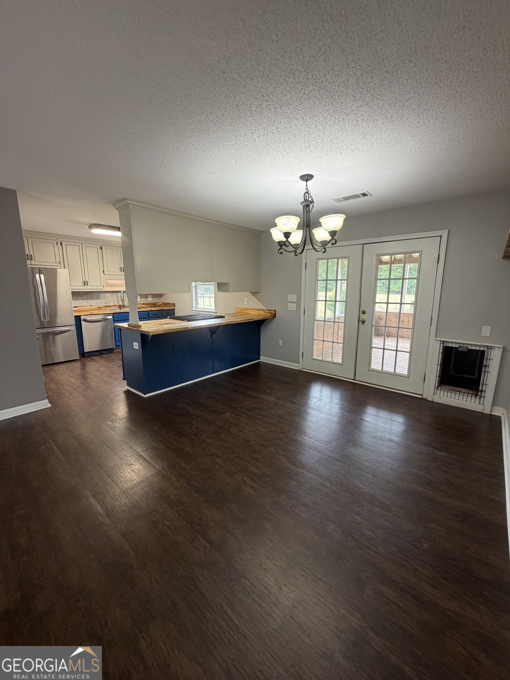 1410 Greensboro Road Madison, GA 30650 - Photo 13 of 17 a living room with hardwood floor and chandelier