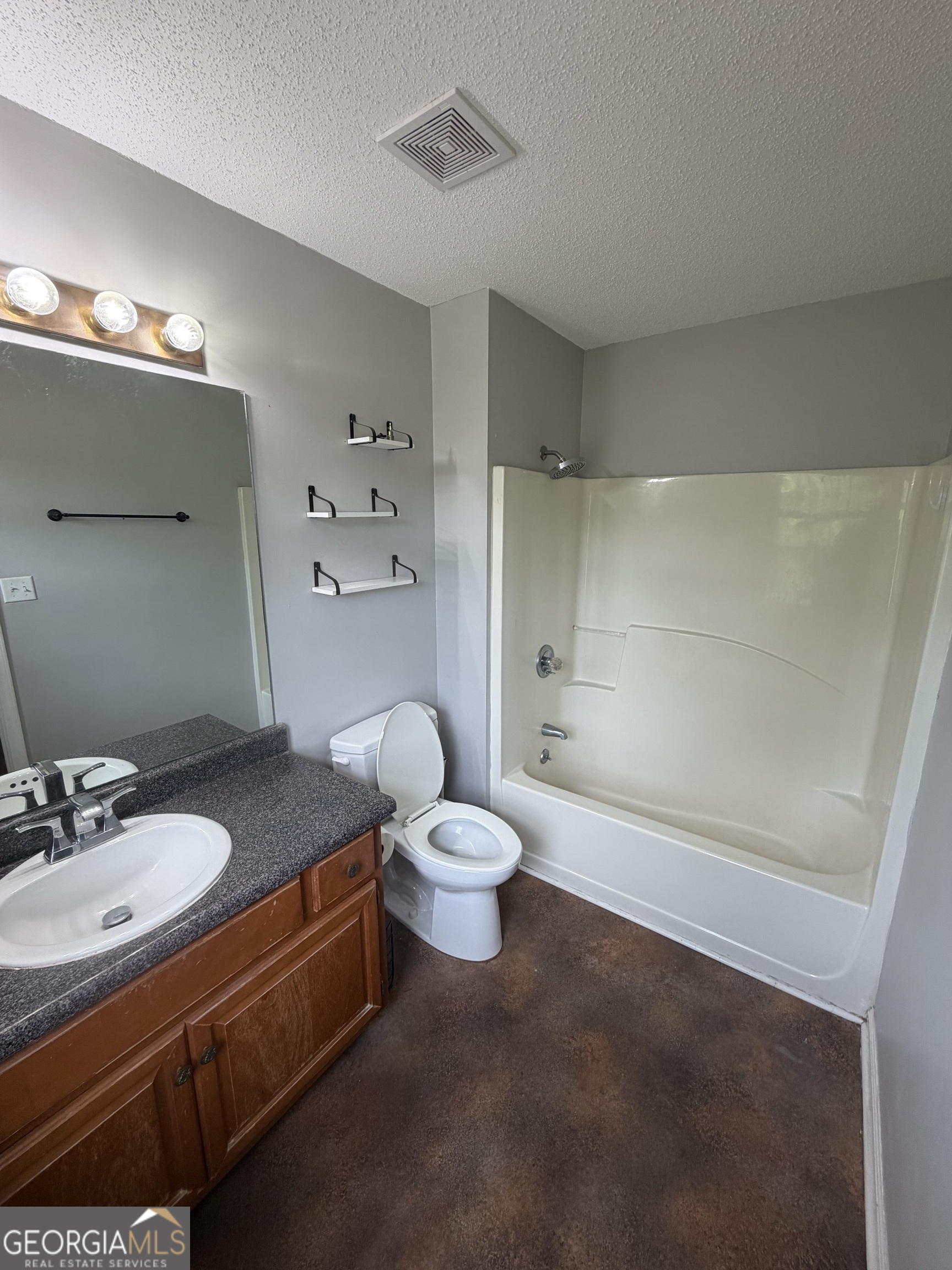 1410 Greensboro Road Madison, GA 30650 - Photo 9 of 17 a bathroom with a granite countertop sink toilet a large mirror a shower and a bathtub
