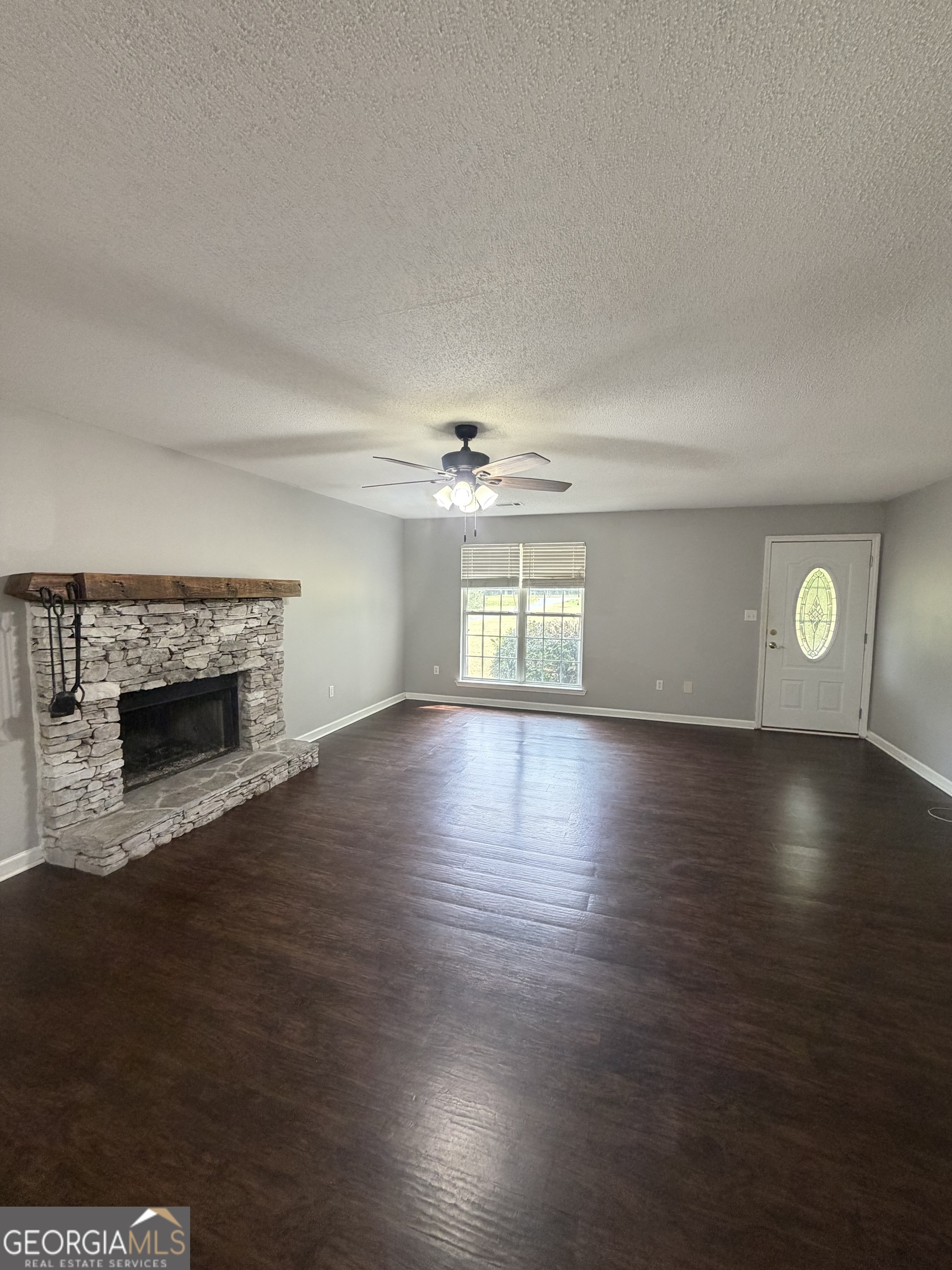 1410 Greensboro Road Madison, GA 30650 - Photo 10 of 17 a view of water heater room with wooden floor and fireplace