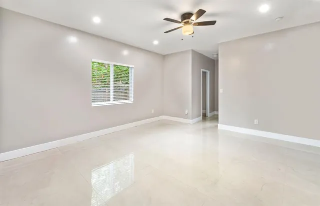 an empty room with a window and a fan