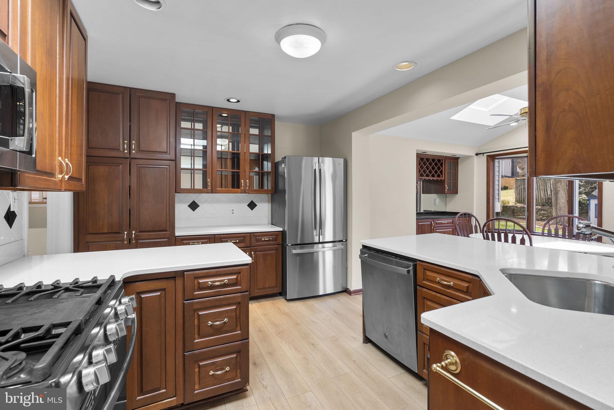 5108 Viking Road Bethesda, MD 20814 - Photo 15 of 51 a kitchen with stainless steel appliances granite countertop a refrigerator a stove and a sink with wooden floors