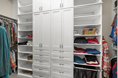 a view of walk in closet with clothes and shoes