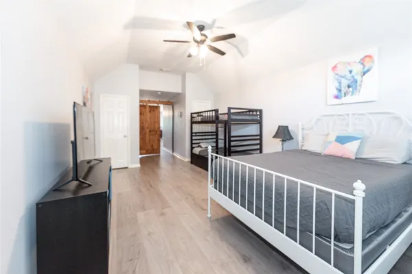 a bedroom with furniture and a chandelier fan