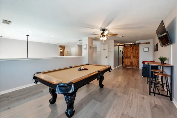 a room with furniture pool table flat screen tv and a chandelier