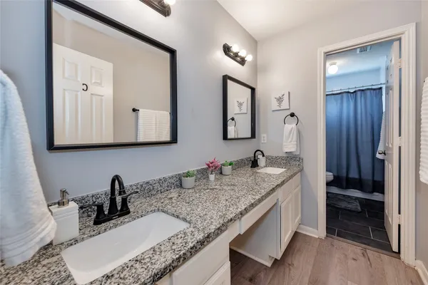 a bathroom with a granite countertop sink and a mirror
