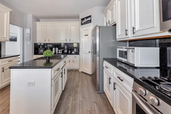 a kitchen with stainless steel appliances a stove refrigerator sink and cabinets
