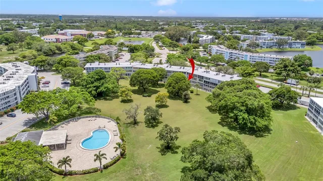 an aerial view of residential house with outdoor space and trees all around