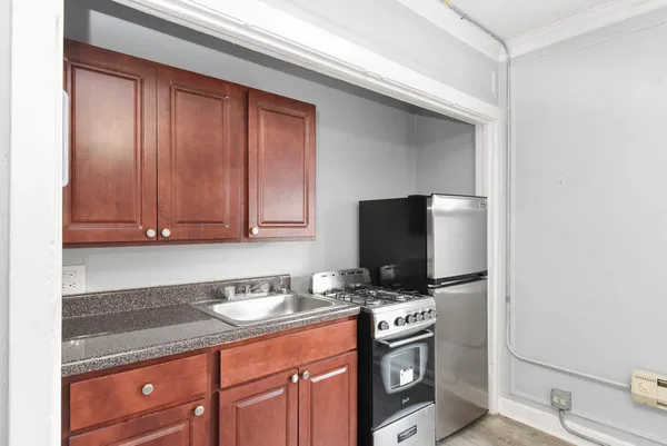 a kitchen with granite countertop a sink and a stove top oven