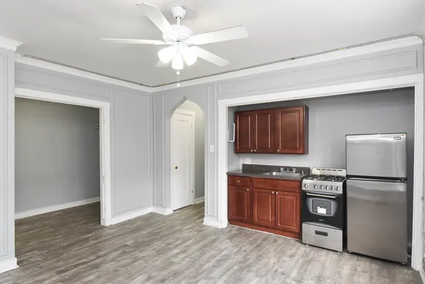 a kitchen with stainless steel appliances granite countertop a refrigerator a stove and a sink with wooden floor