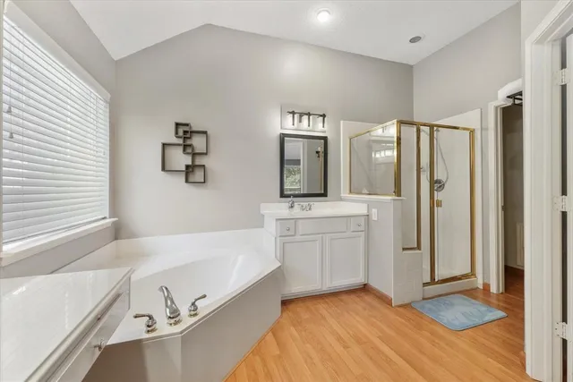 a spacious bathroom with a tub sink and mirror