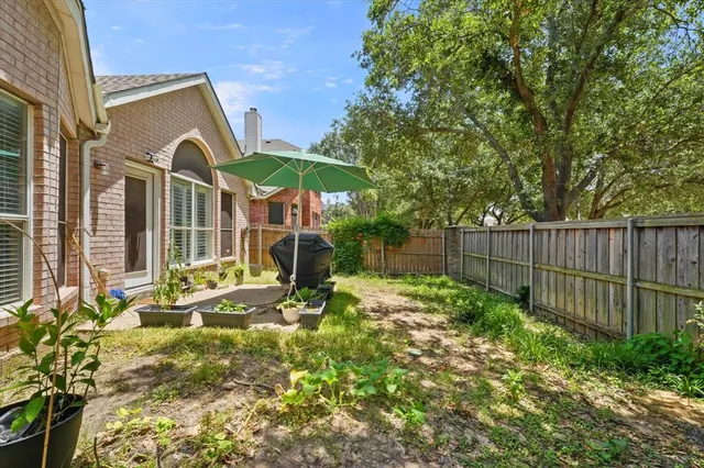 a view of backyard with wooden fence and large trees