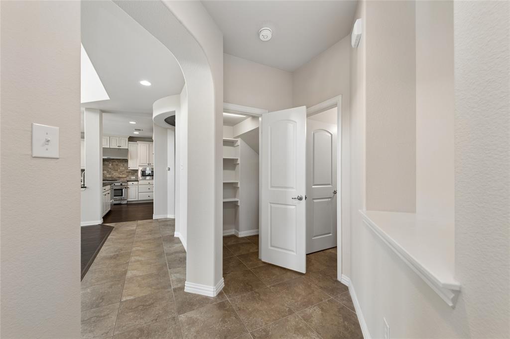 12571 Valley Spring Drive Frisco, TX 75035 - Photo 19 of 39 a view of a hallway with closet and wooden floor