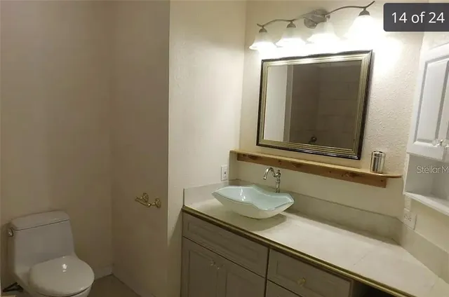 a bathroom with a toilet sink and mirror