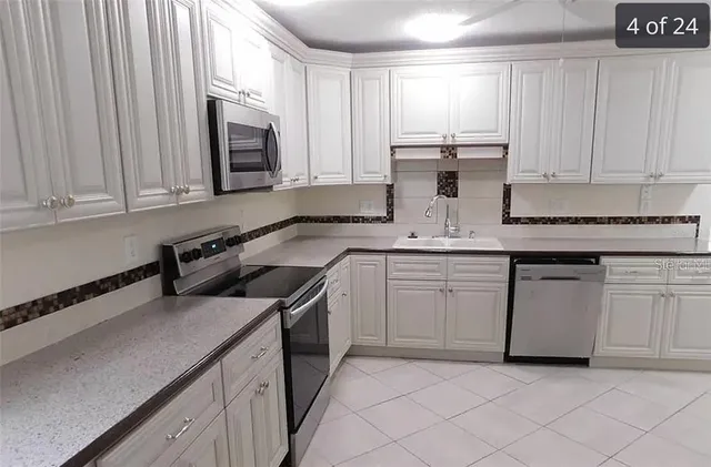 a kitchen with stainless steel appliances granite countertop a sink and a stove
