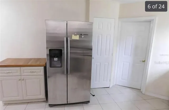 a metallic refrigerator freezer sitting in a kitchen