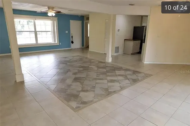 an empty room with windows and cabinet