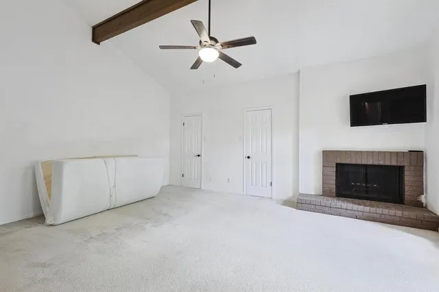 an empty room with fireplace and fan