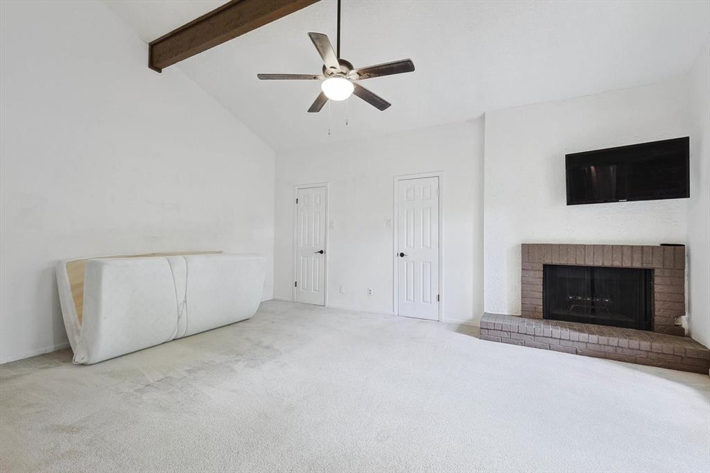 9801 Smokefeather Lane Dallas, TX 75243 - Photo 11 of 27 an empty room with fireplace and fan