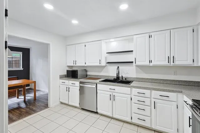 a kitchen with white cabinets appliances and a sink