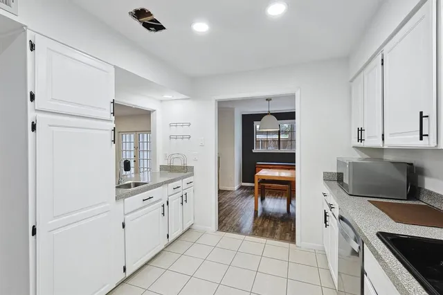 a kitchen with white cabinets and appliances