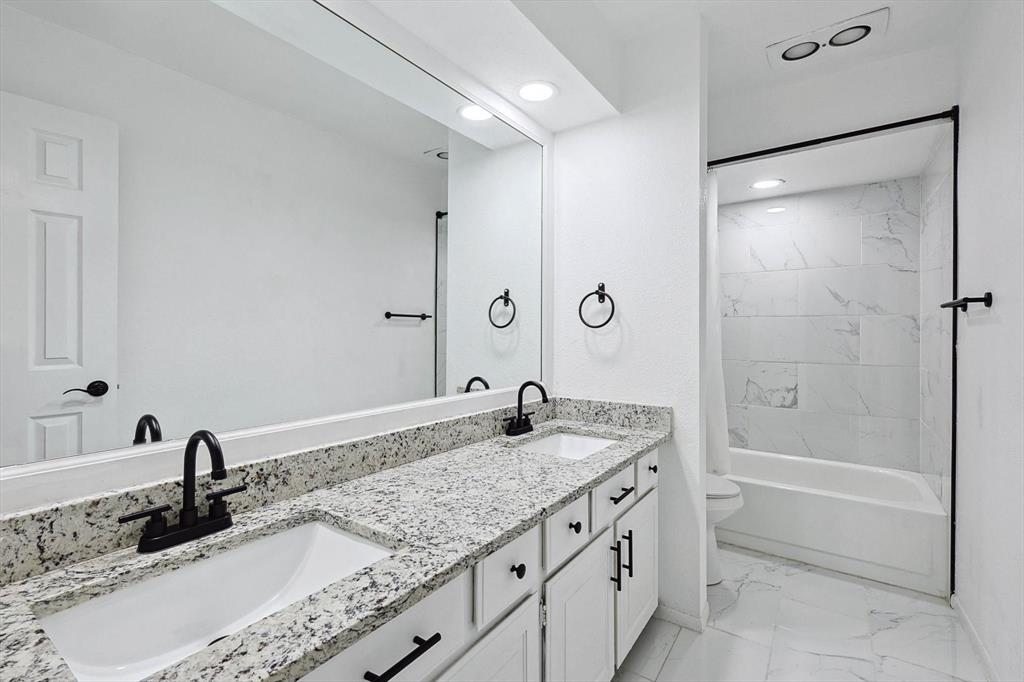 9801 Smokefeather Lane Dallas, TX 75243 - Photo 24 of 27 a bathroom with a granite countertop sink a mirror and a bathtub