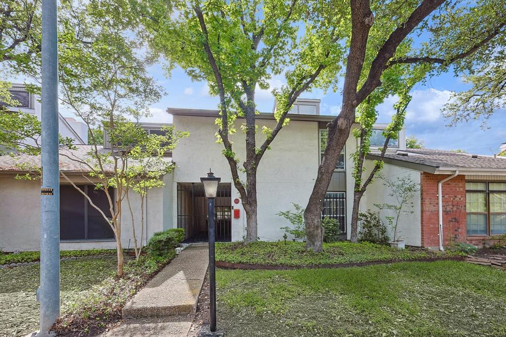 9801 Smokefeather Lane Dallas, TX 75243 - Photo 3 of 27 a view of a wooden house with a big yard and large tree