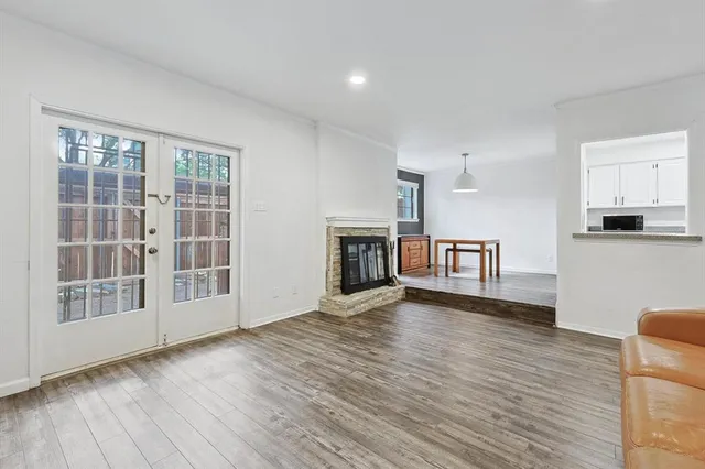 a view of a livingroom with wooden floor and a fireplace