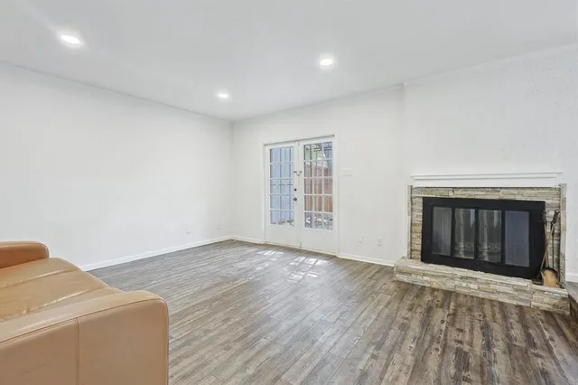 a view of empty room with wooden floor and fireplace