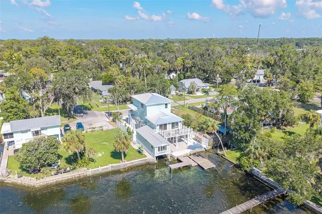 an aerial view of residential houses with outdoor space and a lake view