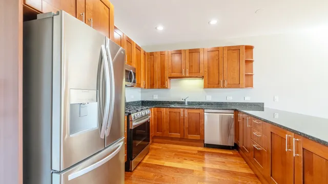 a kitchen with stainless steel appliances granite countertop a refrigerator and a sink