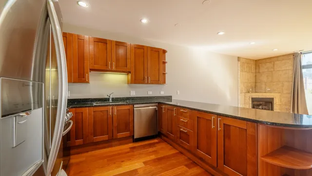 a kitchen with stainless steel appliances granite countertop a refrigerator and a sink