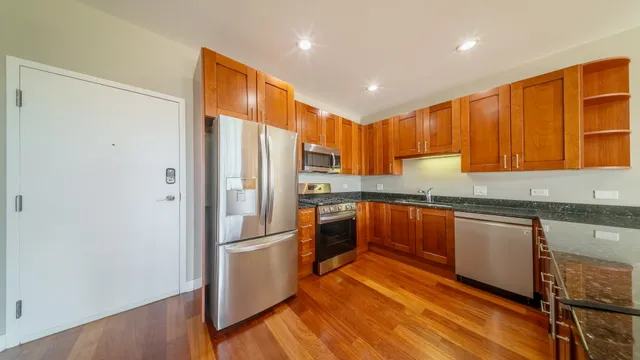 a kitchen with stainless steel appliances granite countertop a refrigerator and a stove top oven