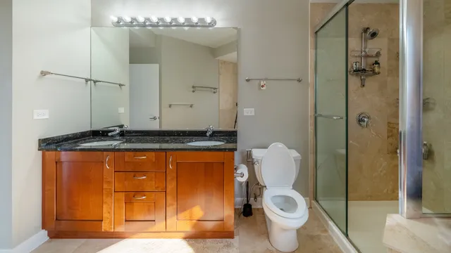 a bathroom with a granite countertop toilet and a sink