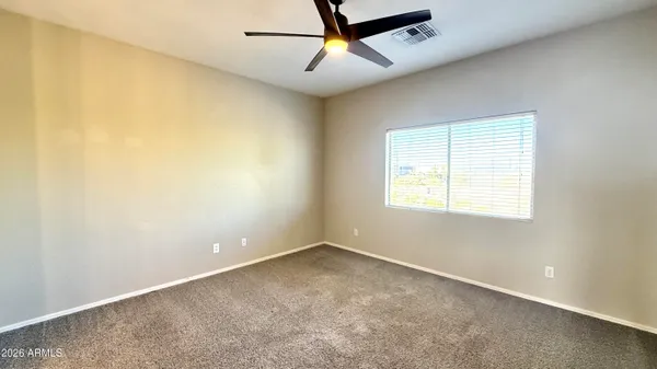 an empty room with a window and a fan