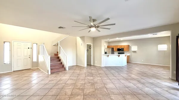 a view of a big room with wooden floor and a kitchen