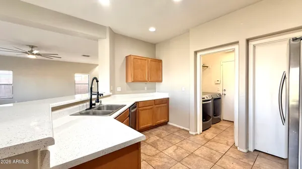 a kitchen with granite countertop a refrigerator and a sink
