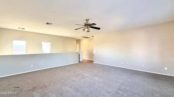 an empty room with a ceiling fan and a window