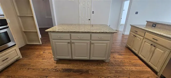 a bathroom with a granite countertop sink and a washer dryer