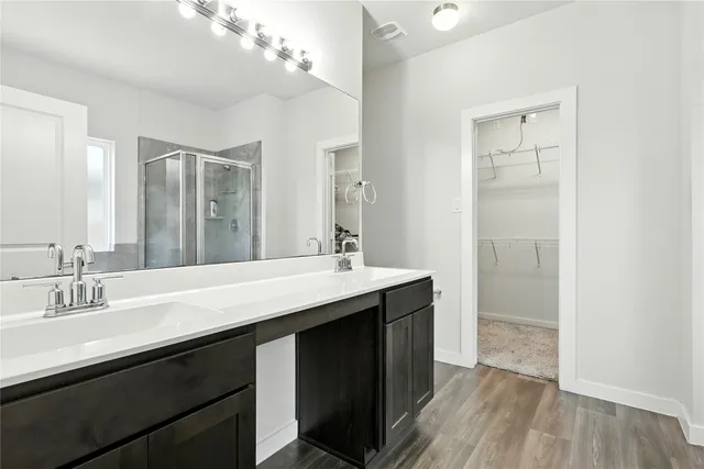 a bathroom with a double vanity sink a mirror and a shower