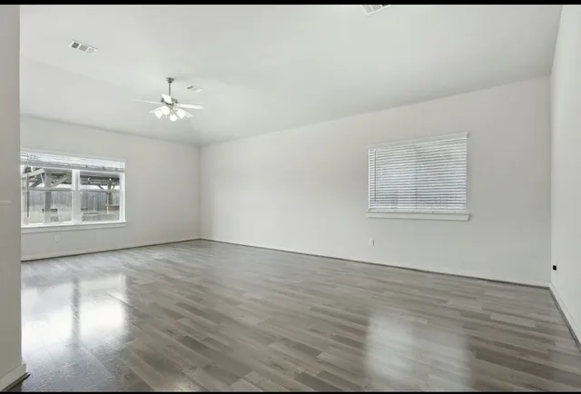 wooden floor in an empty room with a window
