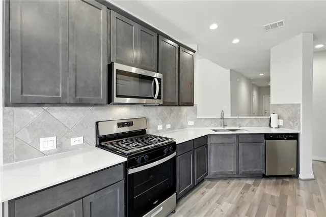a kitchen with a sink a stove and cabinets