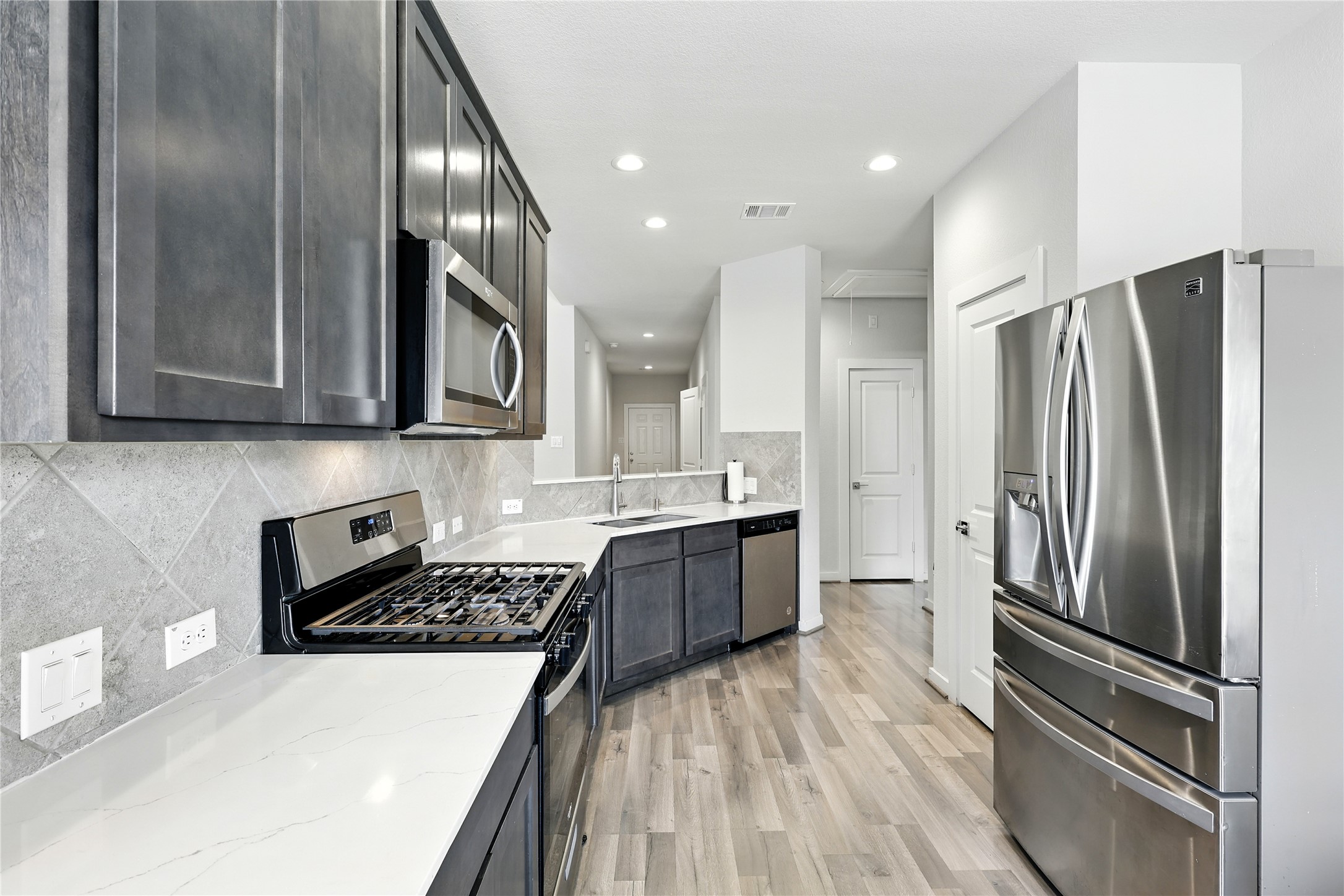 21319 Indigo Ruth Drive Spring, TX 77379 - Photo 20 of 34 a kitchen with stainless steel appliances granite countertop a refrigerator sink and stove