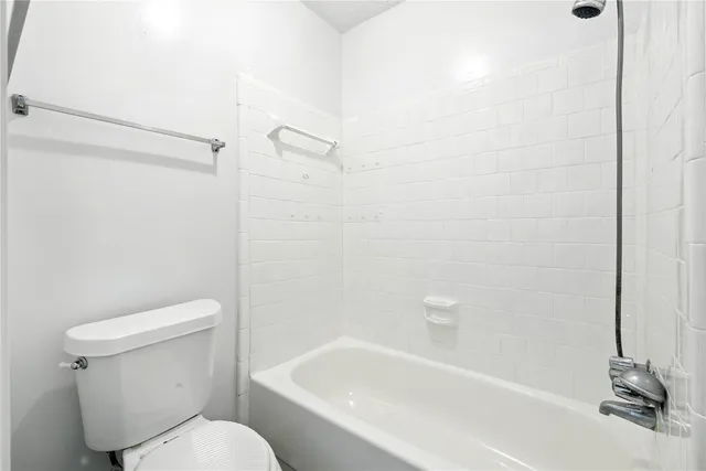 a white toilet sitting next to a bath tub