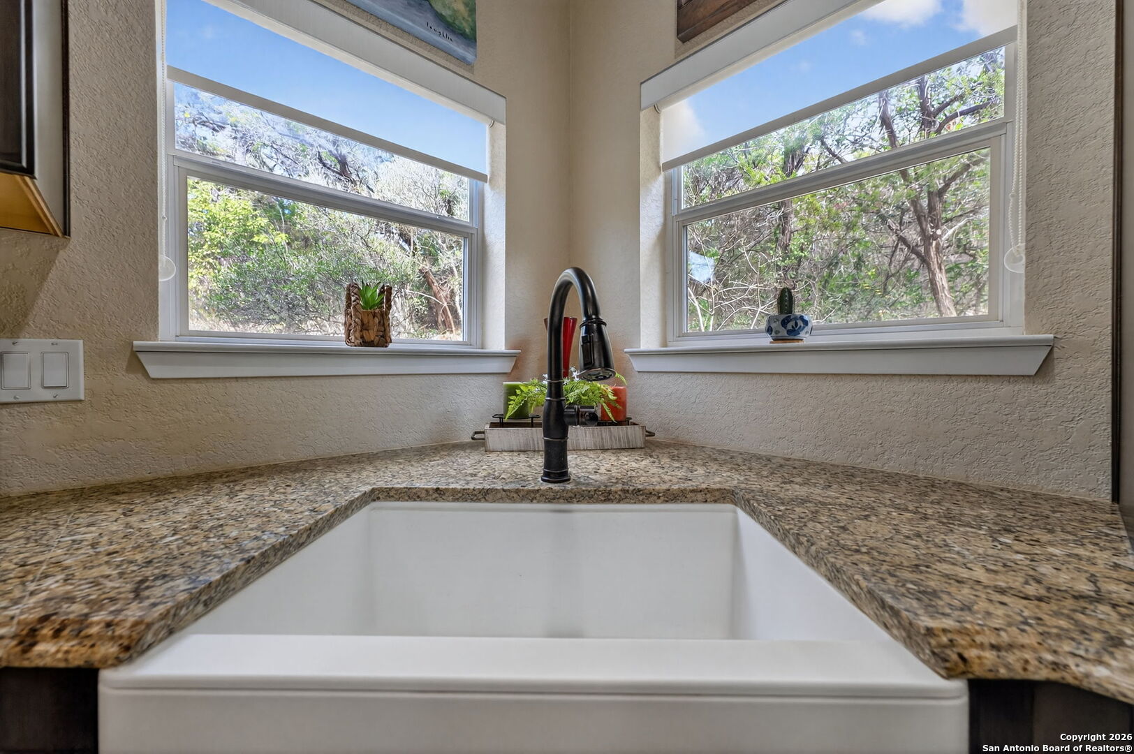 14802 Cross Xd Trail Helotes, TX 78023 - Photo 12 of 58 a kitchen with a granite countertop sink and a window